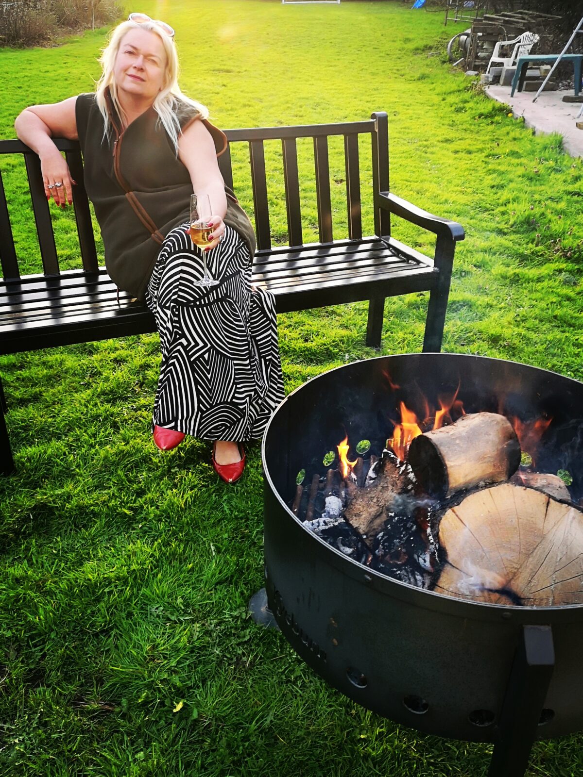 Person Sitting on Bench and firepit